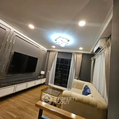 Elegant living room with modern decor, featuring a plush sofa, stylish lighting, and a large flat-screen TV.