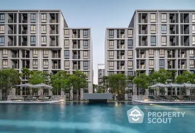 Luxurious modern apartment complex with stunning poolside view and lush greenery