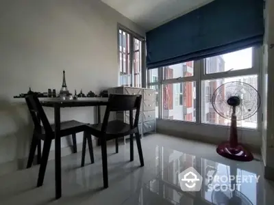 Modern study room with large windows and sleek furniture in a high-rise apartment.