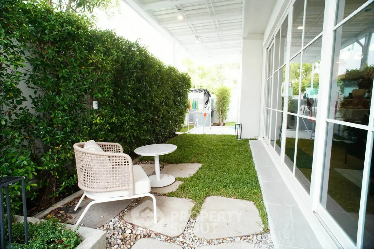 Charming garden patio with modern seating and lush greenery, perfect for relaxation and outdoor enjoyment.