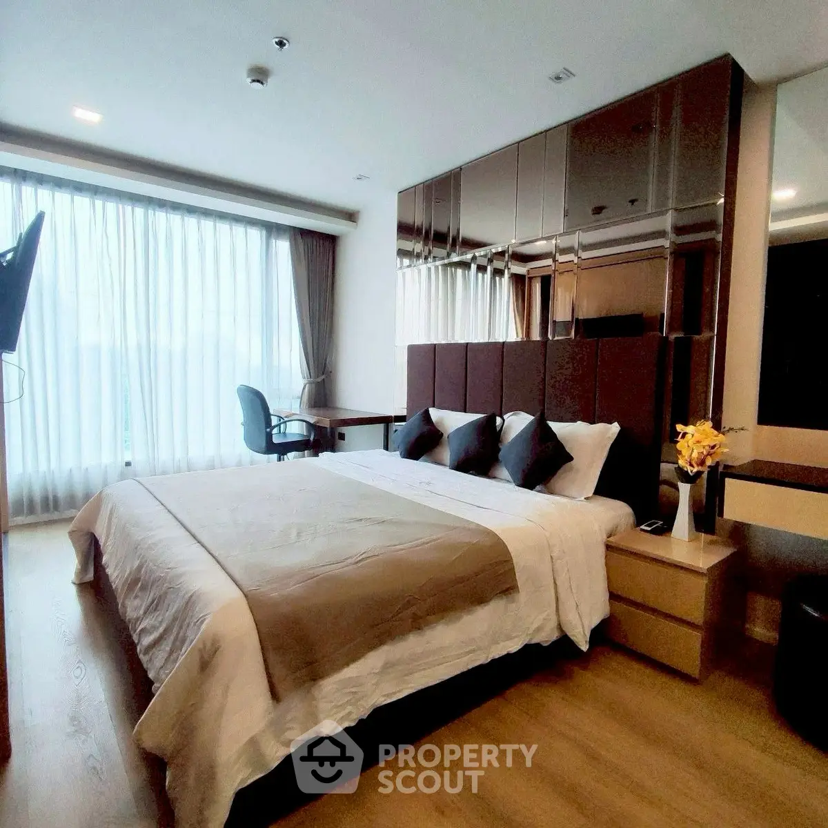 Luxurious modern bedroom with large window and elegant decor in prime real estate location.