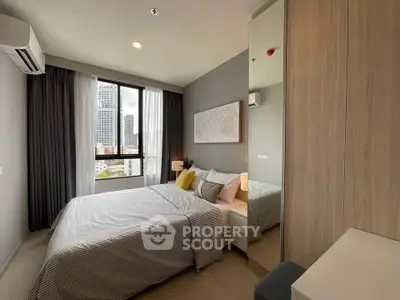 Modern bedroom with city view, featuring cozy bed and stylish decor.
