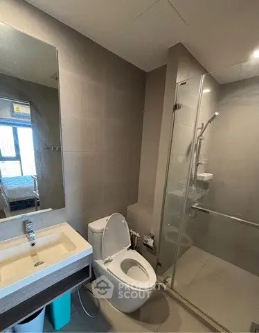 Modern bathroom with glass shower and sleek fixtures in a contemporary apartment.