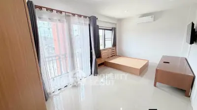 Spacious bedroom with large windows and modern furnishings