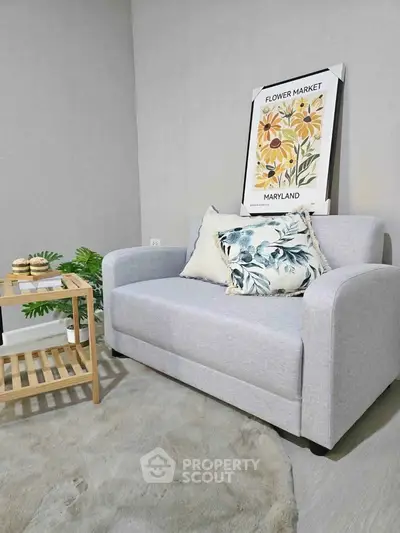 Cozy living room with stylish sofa and decorative pillows, perfect for relaxation.