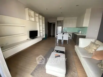 Modern open-plan living room with sleek kitchen and cozy seating area, perfect for contemporary living.