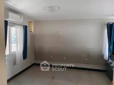 Spacious empty room with large windows and air conditioning unit