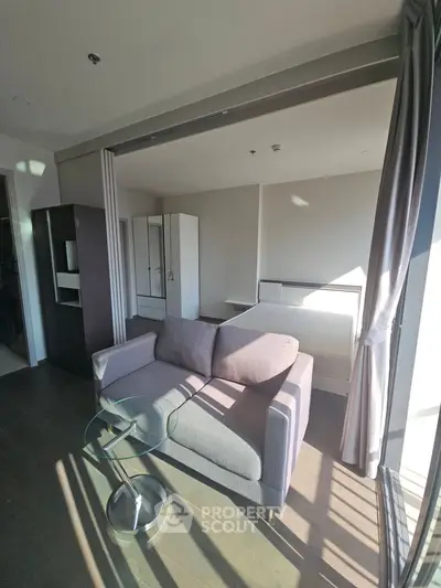 Modern studio apartment with cozy sofa and ample natural light