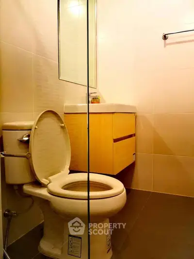 Modern bathroom with sleek fixtures and glass partition, ideal for contemporary living spaces.