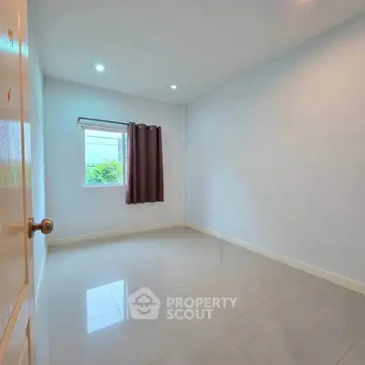 Spacious empty room with window and curtain, perfect for customization.