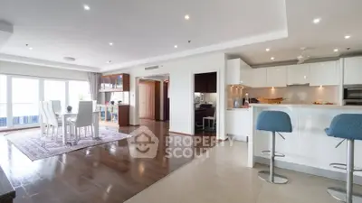 Spacious open-plan living and dining area with modern kitchen and elegant decor.