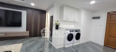 Modern living room with sleek design and in-unit laundry appliances