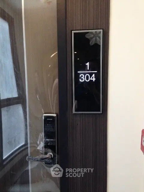Modern apartment door with electronic lock and room number 1304 displayed.