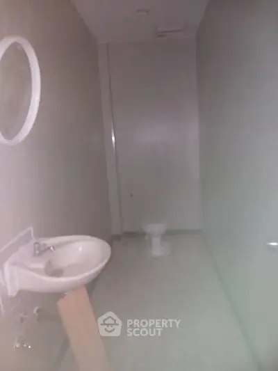 Compact bathroom with basic fixtures and minimal design, ideal for small spaces.