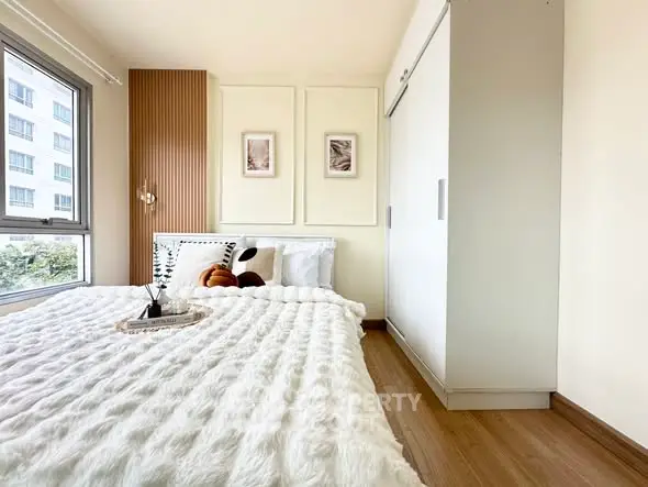 Cozy bedroom with plush bedding and modern decor in a high-rise apartment.