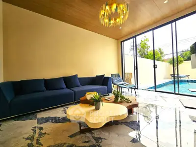 Luxurious living room with pool view, modern furniture, and elegant lighting in a stylish home.