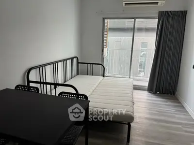 Modern minimalist bedroom with sleek metal bed frame and large window for natural light.