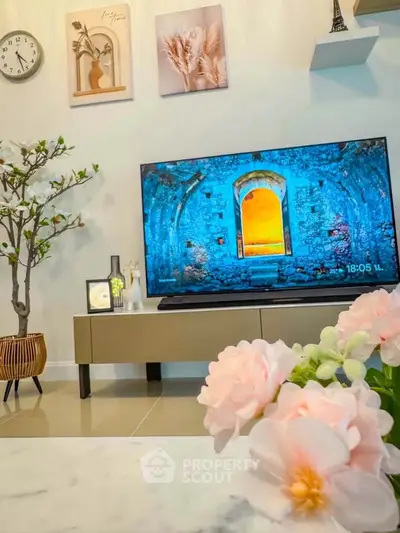 Stylish living room with modern decor and large TV, perfect for relaxation.