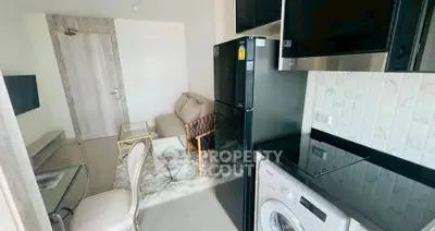 Modern apartment interior with cozy living area and kitchen appliances.