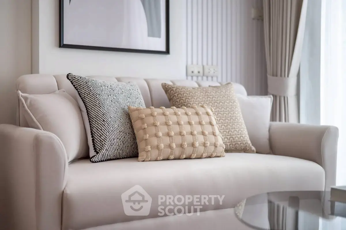 Elegant living room with plush sofa and stylish cushions in a modern apartment.