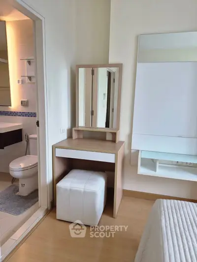 Modern bedroom with vanity and ensuite bathroom in stylish apartment