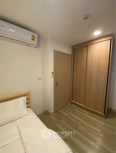 Modern bedroom with air conditioning and wooden wardrobe in a cozy apartment.