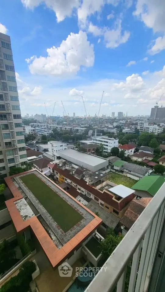 Stunning cityscape view from high-rise balcony with clear blue skies.
