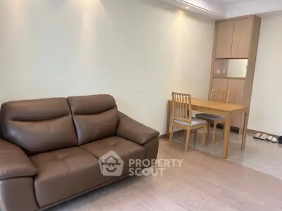 Modern living room with brown leather sofa and wooden dining set