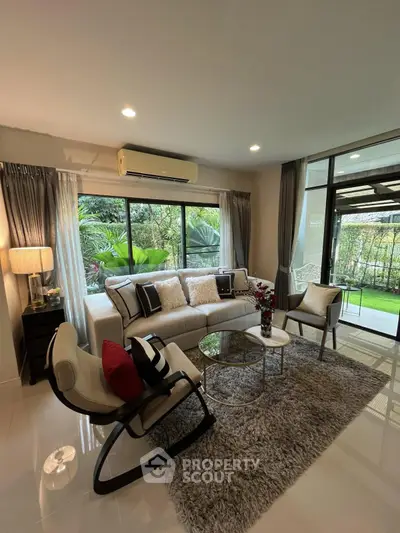 Elegant living room with garden view, modern furniture, and cozy ambiance.