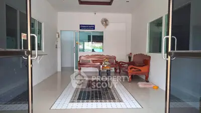 Inviting entrance with elegant wooden furniture and tiled flooring in a modern building lobby.