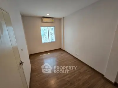 Spacious empty room with wooden flooring and natural light, perfect for customization.