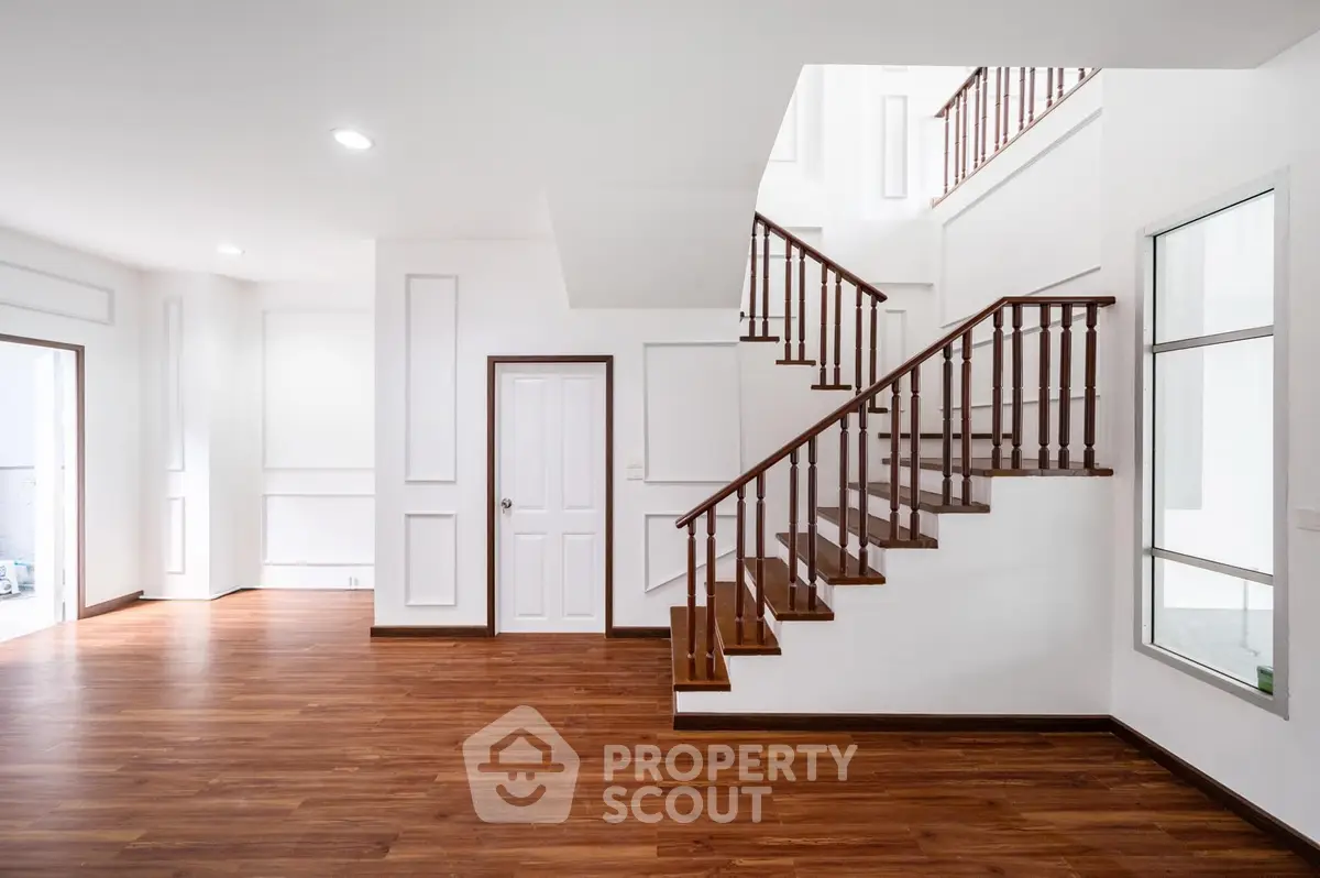 Spacious modern interior with elegant wooden staircase and bright open layout