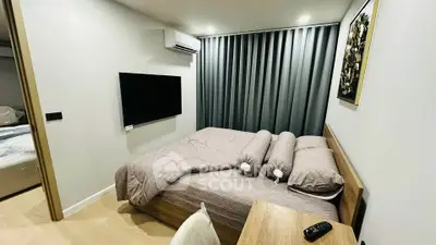 Modern bedroom with stylish decor and wall-mounted TV in a cozy apartment.