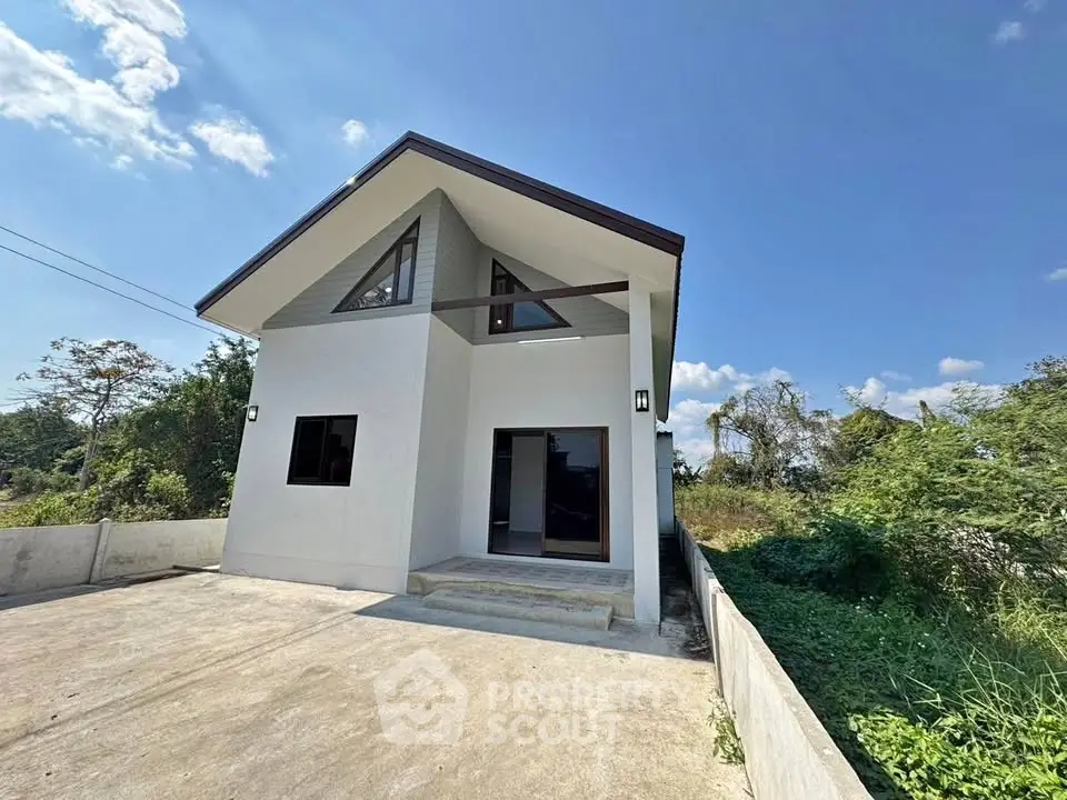 Modern minimalist house with spacious driveway and lush surroundings.