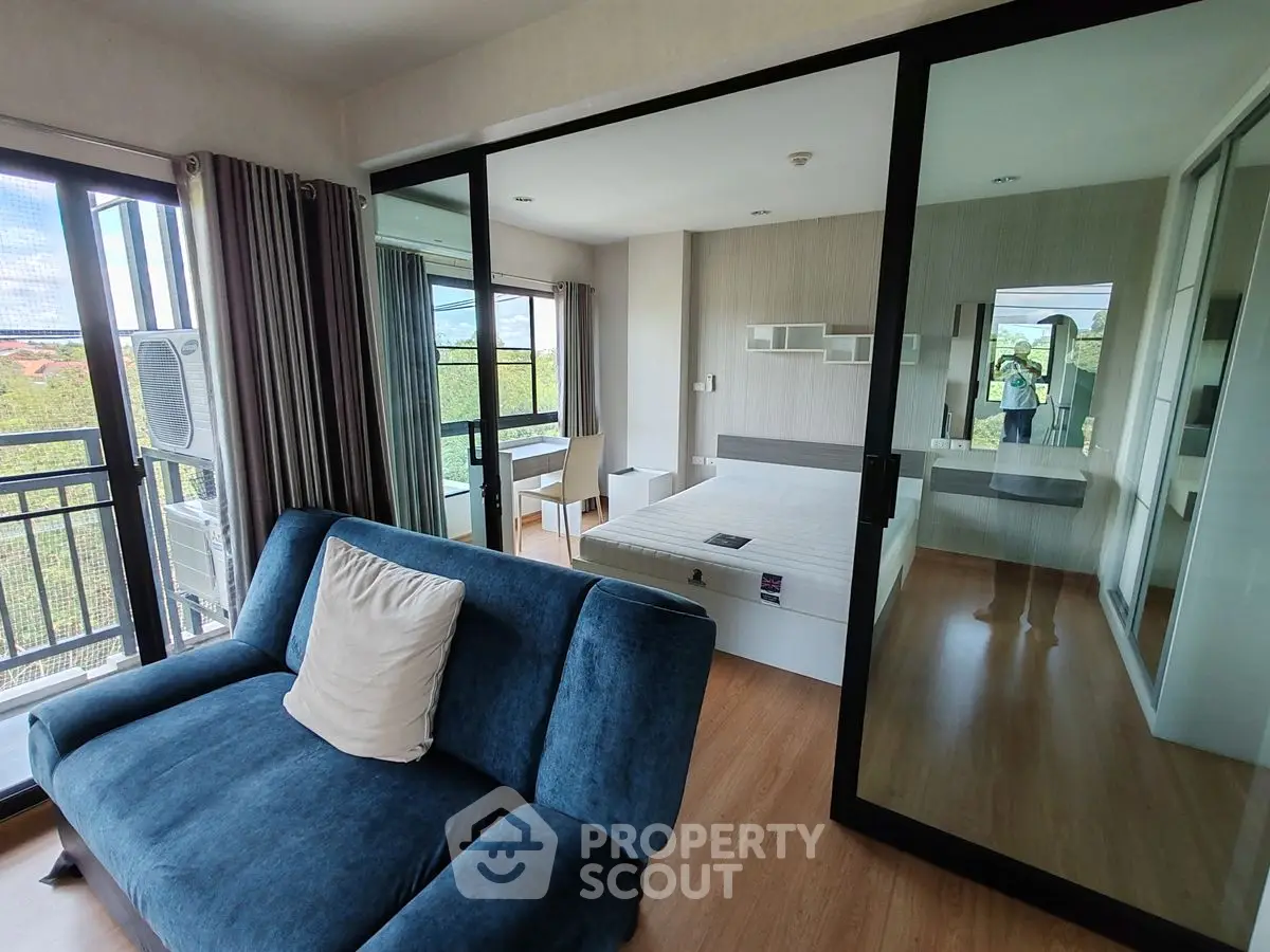 Modern apartment with glass partition, featuring a cozy living area and spacious bedroom with scenic views.