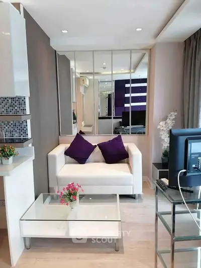 Modern living room with white sofa, glass coffee table, and stylish decor