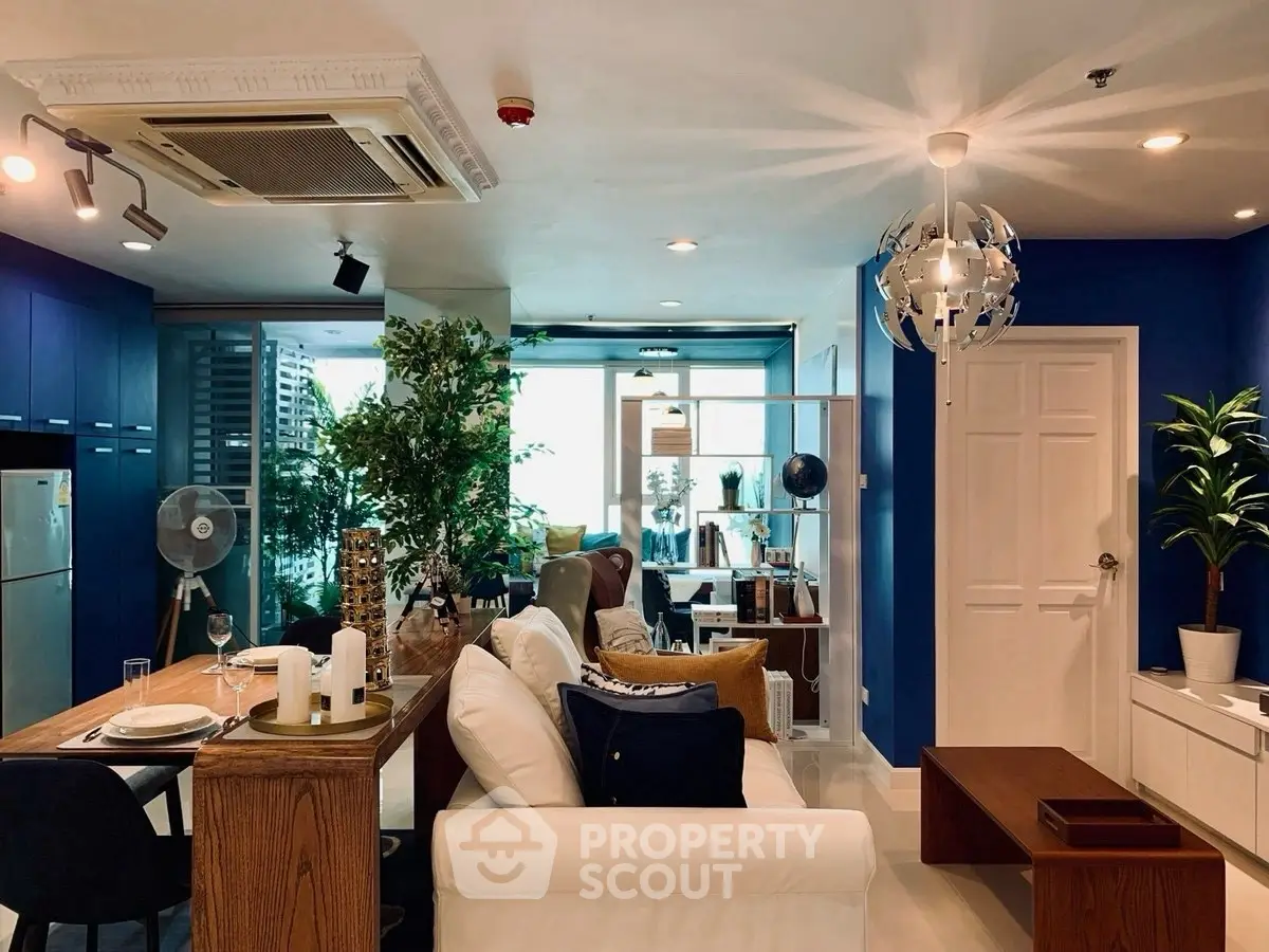 Stylish modern living room with blue accents and open layout, featuring elegant furniture and natural light.