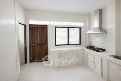 Spacious kitchen with modern gas stove and ample storage space