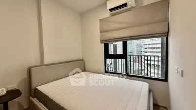 Modern bedroom with large window and air conditioning in urban apartment
