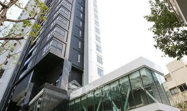 Modern high-rise building with sleek glass facade and contemporary design.