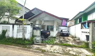 Charming single-story house with driveway and gated entrance in a suburban neighborhood.