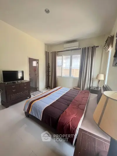 Spacious bedroom with modern decor and natural light, featuring a cozy bed and stylish furniture.