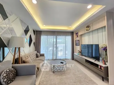 Modern living room with stylish decor and large TV, featuring elegant lighting and cozy seating.
