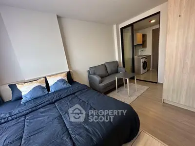 Modern studio apartment with cozy bed and compact living area