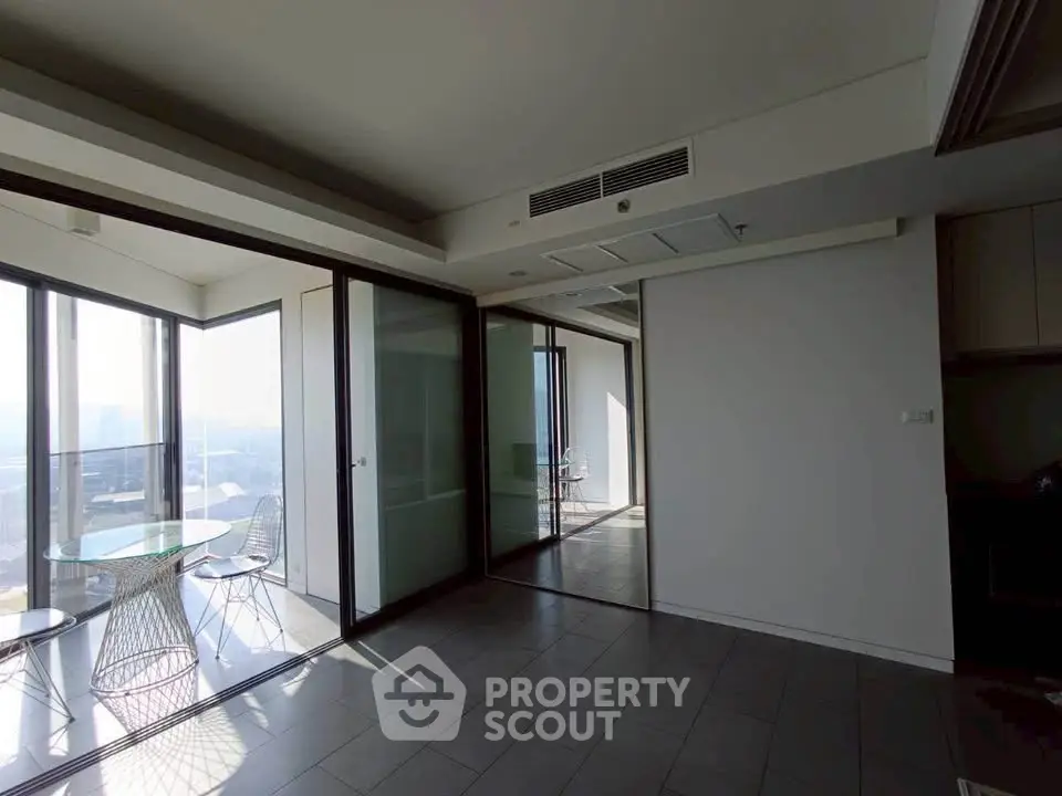 Spacious modern apartment with floor-to-ceiling windows and stunning city views.