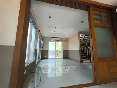 Spacious living room with sliding doors and staircase in modern home