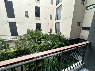 Charming balcony with lush greenery and modern railing in urban setting