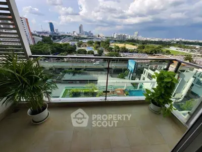 Stunning balcony view of cityscape with lush greenery and modern buildings.