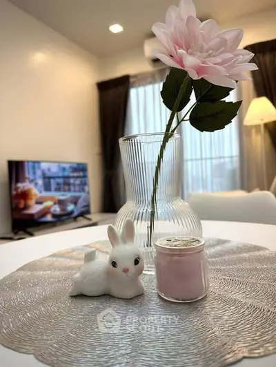 Charming living room with elegant decor, featuring a stylish vase and cozy ambiance, perfect for relaxation.