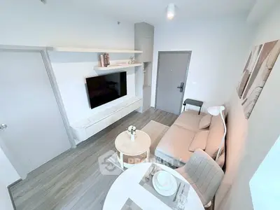 Modern living room with sleek furniture and wall-mounted TV in a cozy apartment.